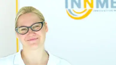 Vaistų konsultantės portretas, vaistininkė su akiniais, šypsosi, sveikatos ir vaistų tema.